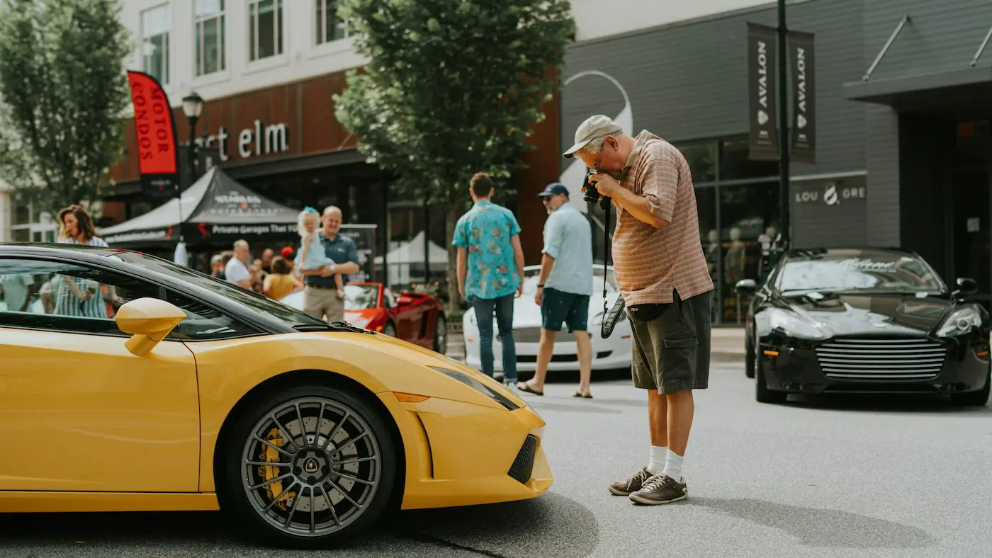 Een freelance autoredacteur neemt een foto van een sportwagen.
