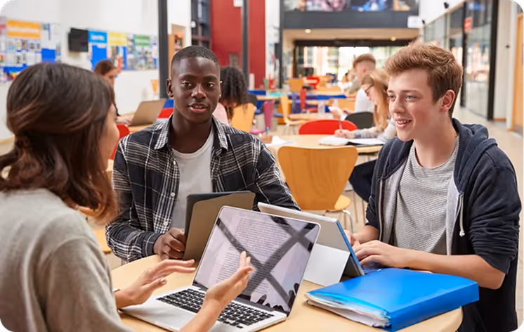 An image of three student around a table talking