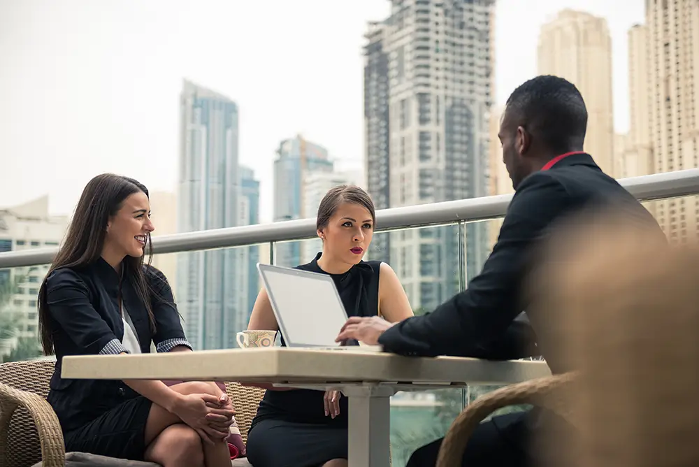People sitting at a table outside and having a discussion