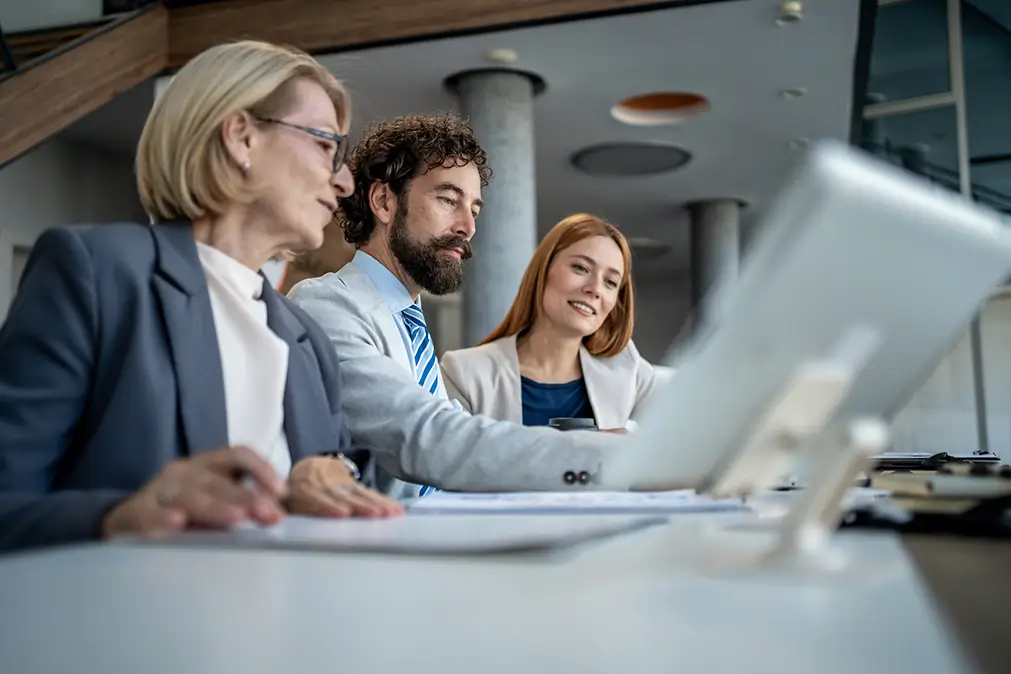 Three people looking at a screen