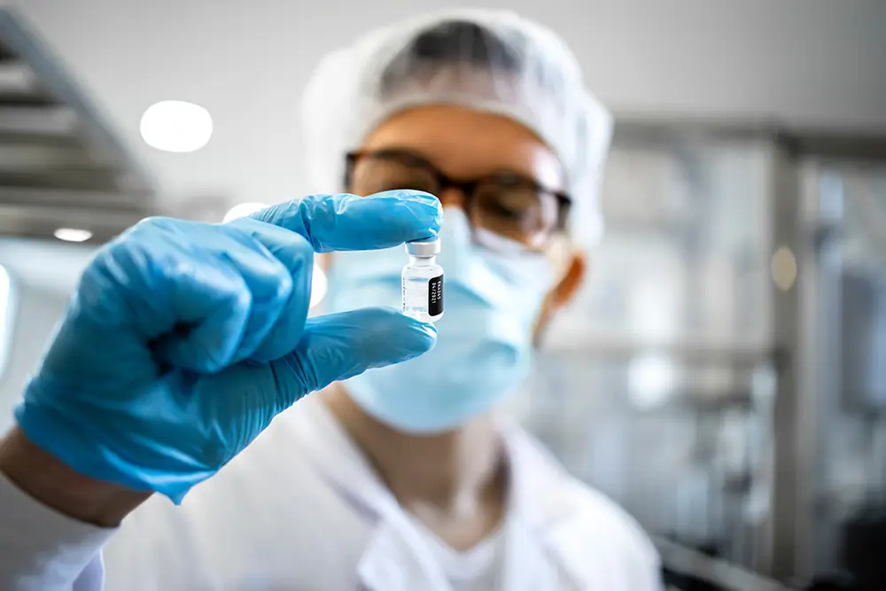 A surgeon looking at a small vial