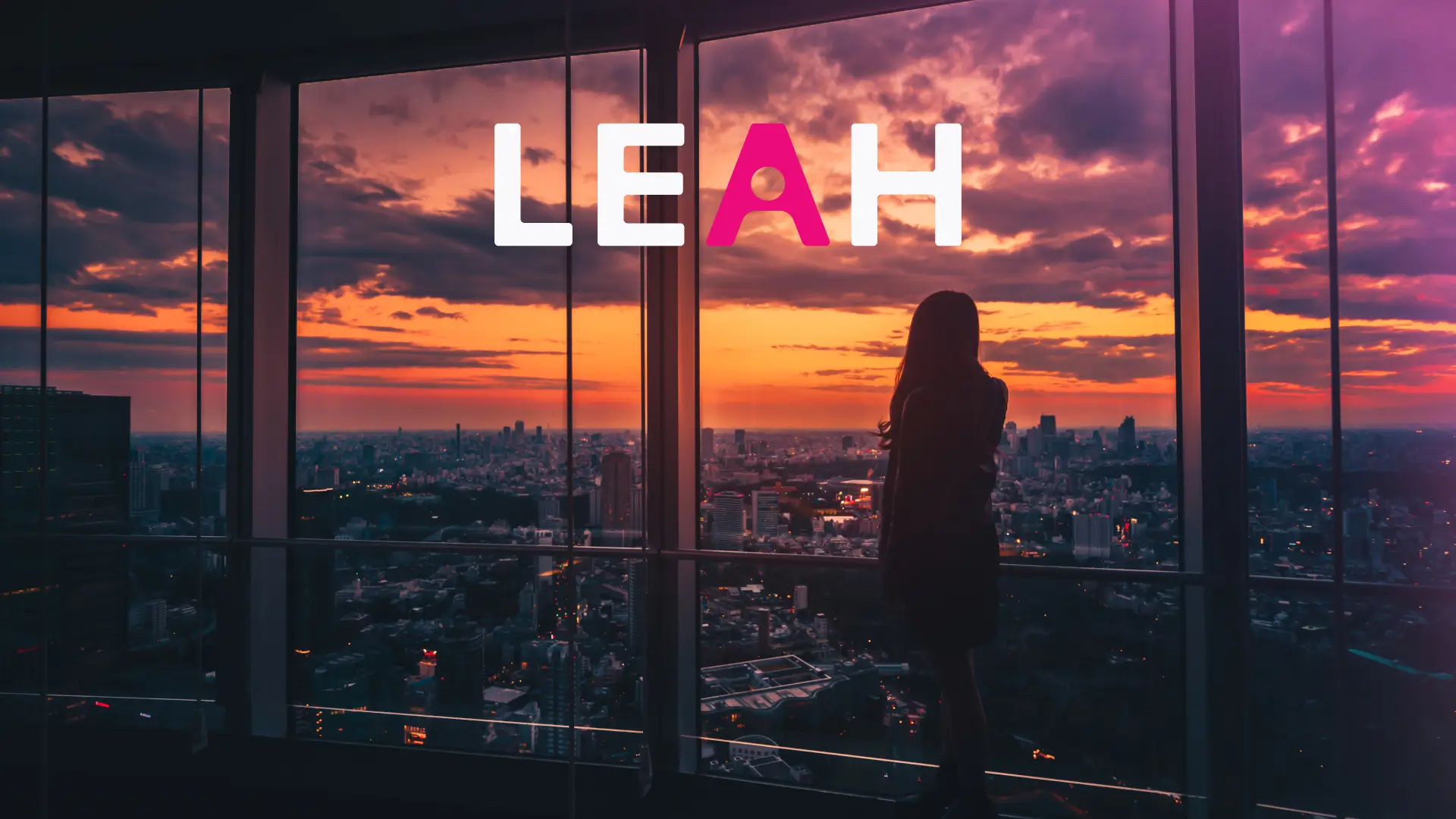 A women looks out of a skyscraper at sunset