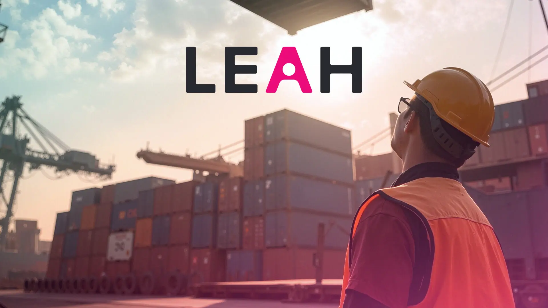 A man watches as shipping containers are moved around a shipyard