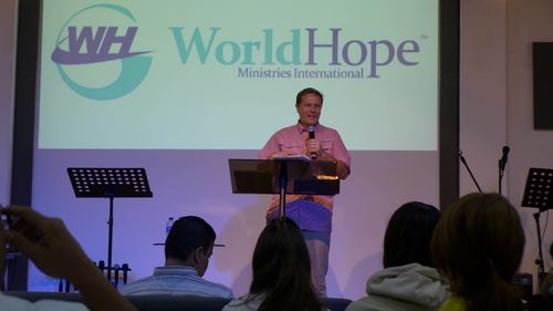 A man giving a speech at a world hope event.