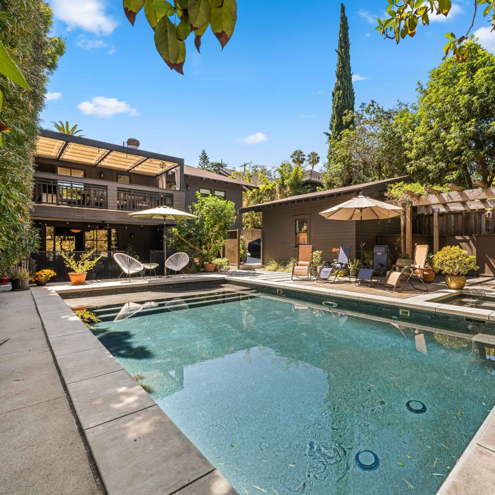 Beautiful brick residence with a grey roof and dormer windows in the tree-lined Larchmont Village neighborhood of Los Angeles, offered by Nonpareil Stays.