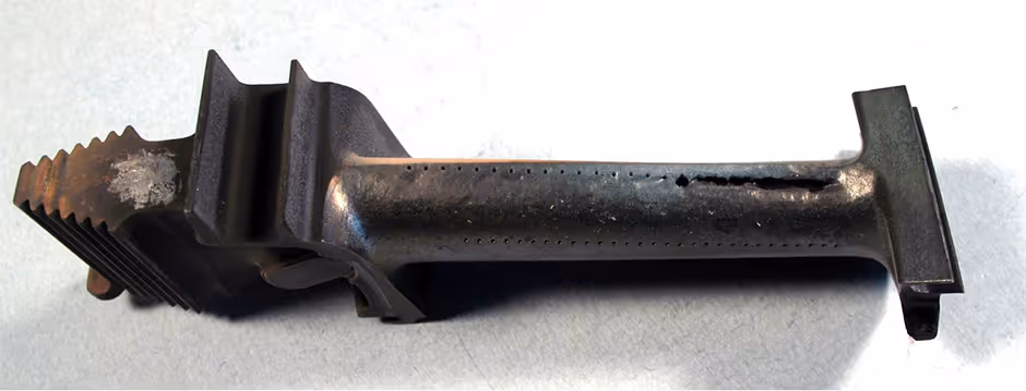 Gas turbine blade with coating erosion and material loss near trailing edge from service exposure