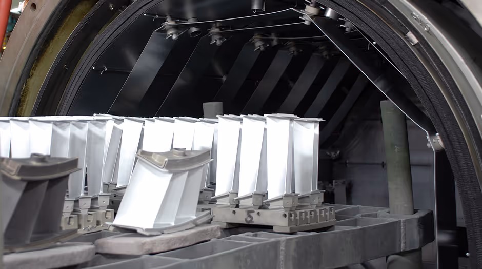 Gas turbine blades loaded inside an industrial heat treatment furnace during controlled thermal processing.