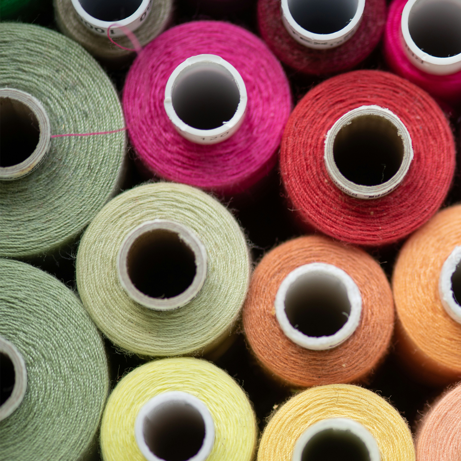 Colorful spools of thread stacked on top of one another