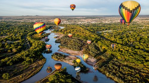 Aerial shot of hot air balloons flying over the Rio Grande