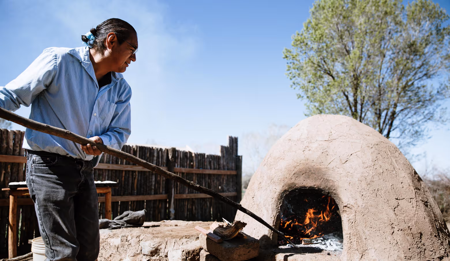 Man pulling baked item out of an Horno oven