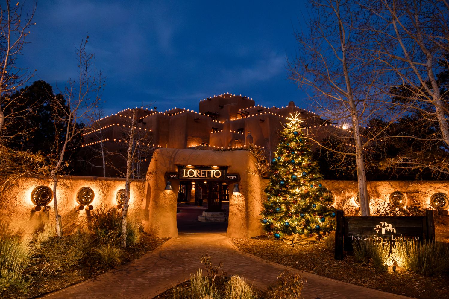 Inn and Spa at Loretto exterior at night with farolitos on building