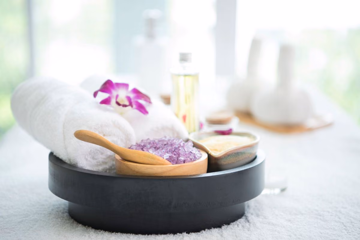 Various spa accoutrements purple salts oils and an orchid