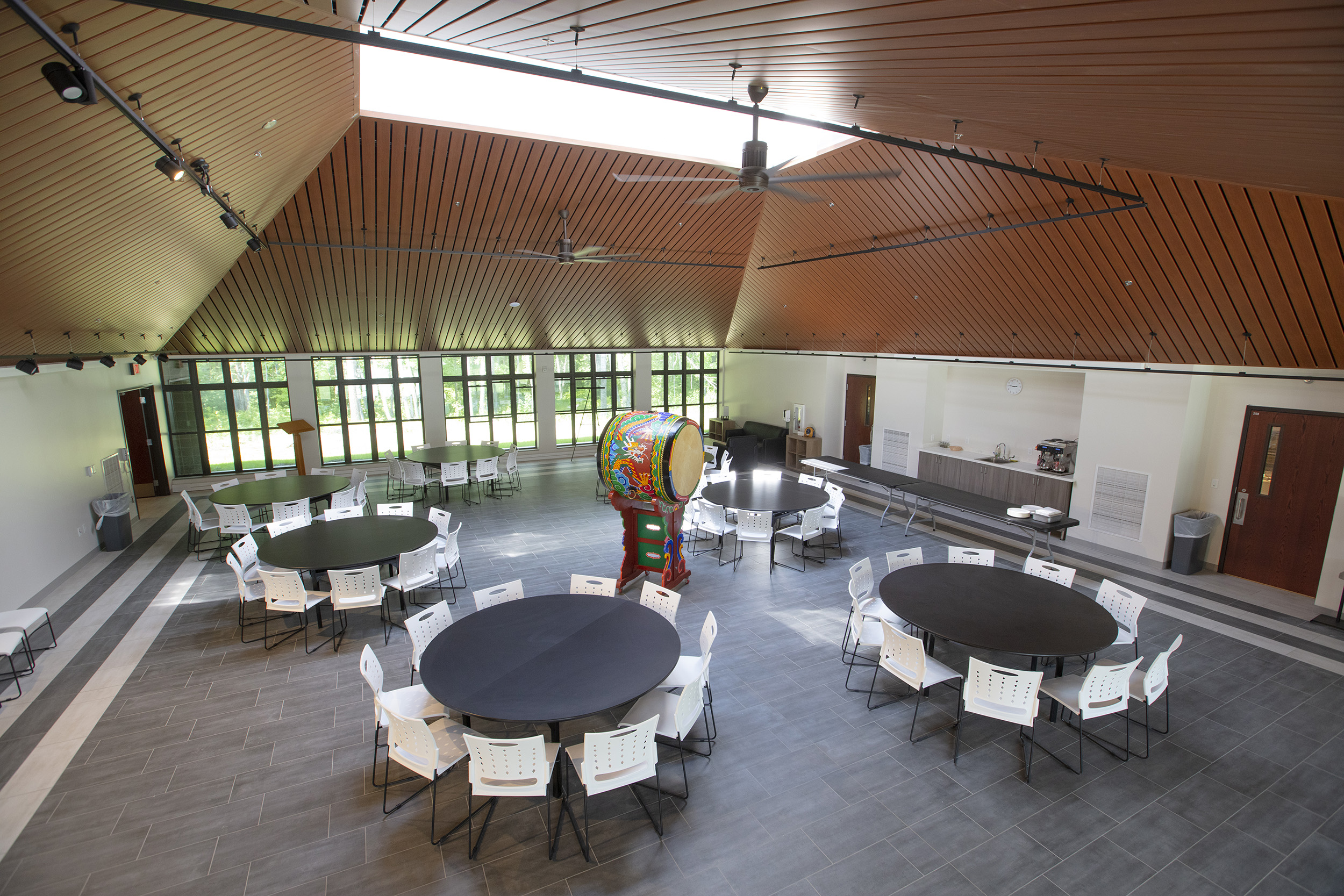 Korean dining hall overview; round tables and chairs surrounding a large drum.