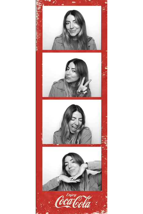 Black and white photo strip of a woman making four different expressions and poses, including smiling, peace sign, laughing, and resting her chin on her hands, with a red Coca-Cola branded border.