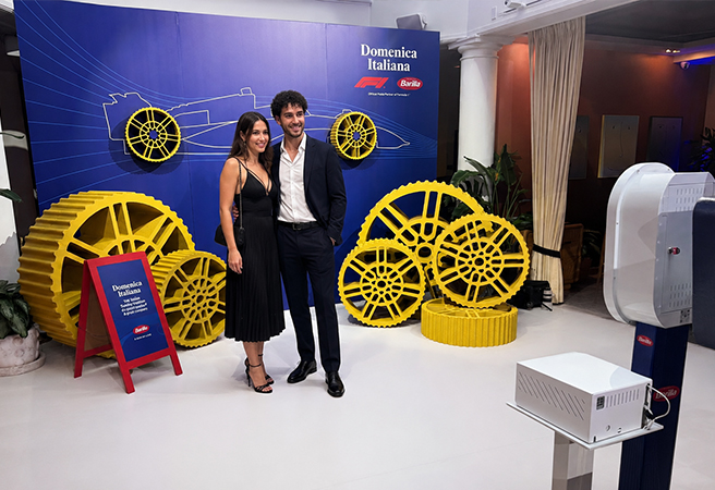Two guests posing beside a Capture Pod photo booth at a branded corporate activation in Boston