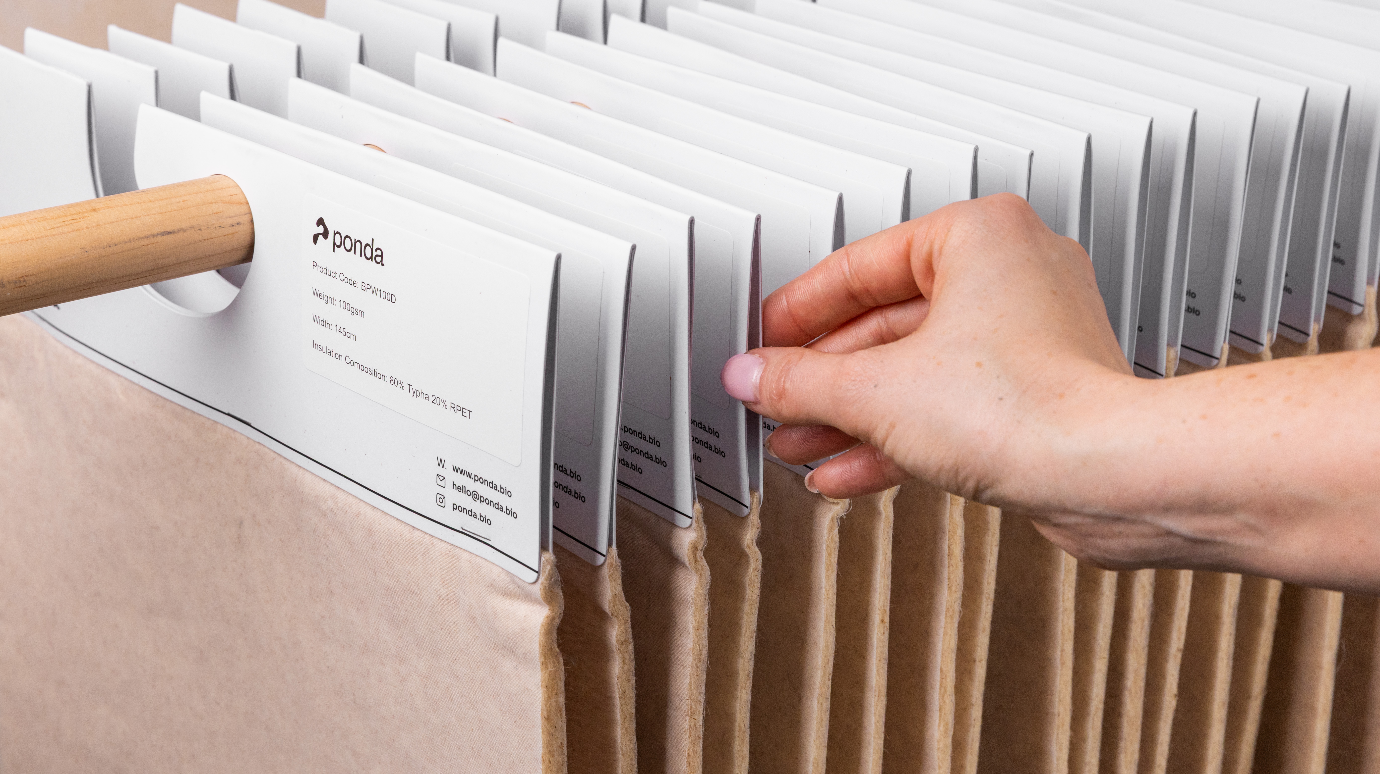 close up to the hands of a person supporting a sample of biopuff material