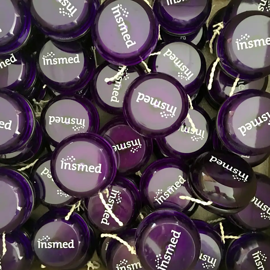 Custom printed purple yo-yos with white biotech company logo for pharmaceutical promotional giveaways