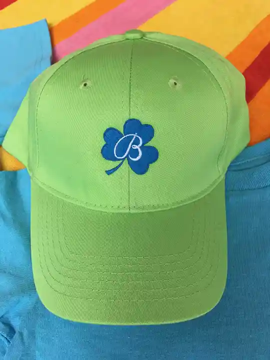 Custom embroidered green baseball cap with blue shamrock design for seasonal promotional apparel