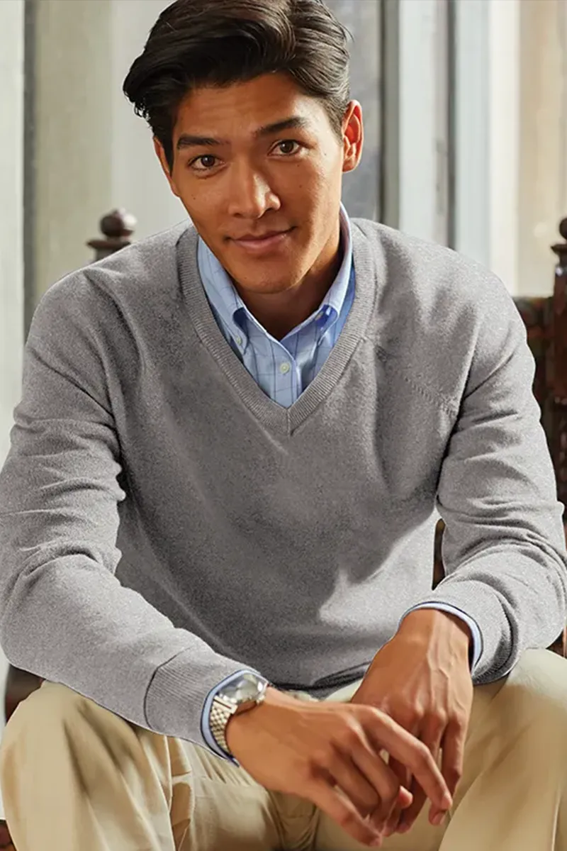 Man wearing a Brooks Brothers gray v-neck sweater over a blue checked shirt