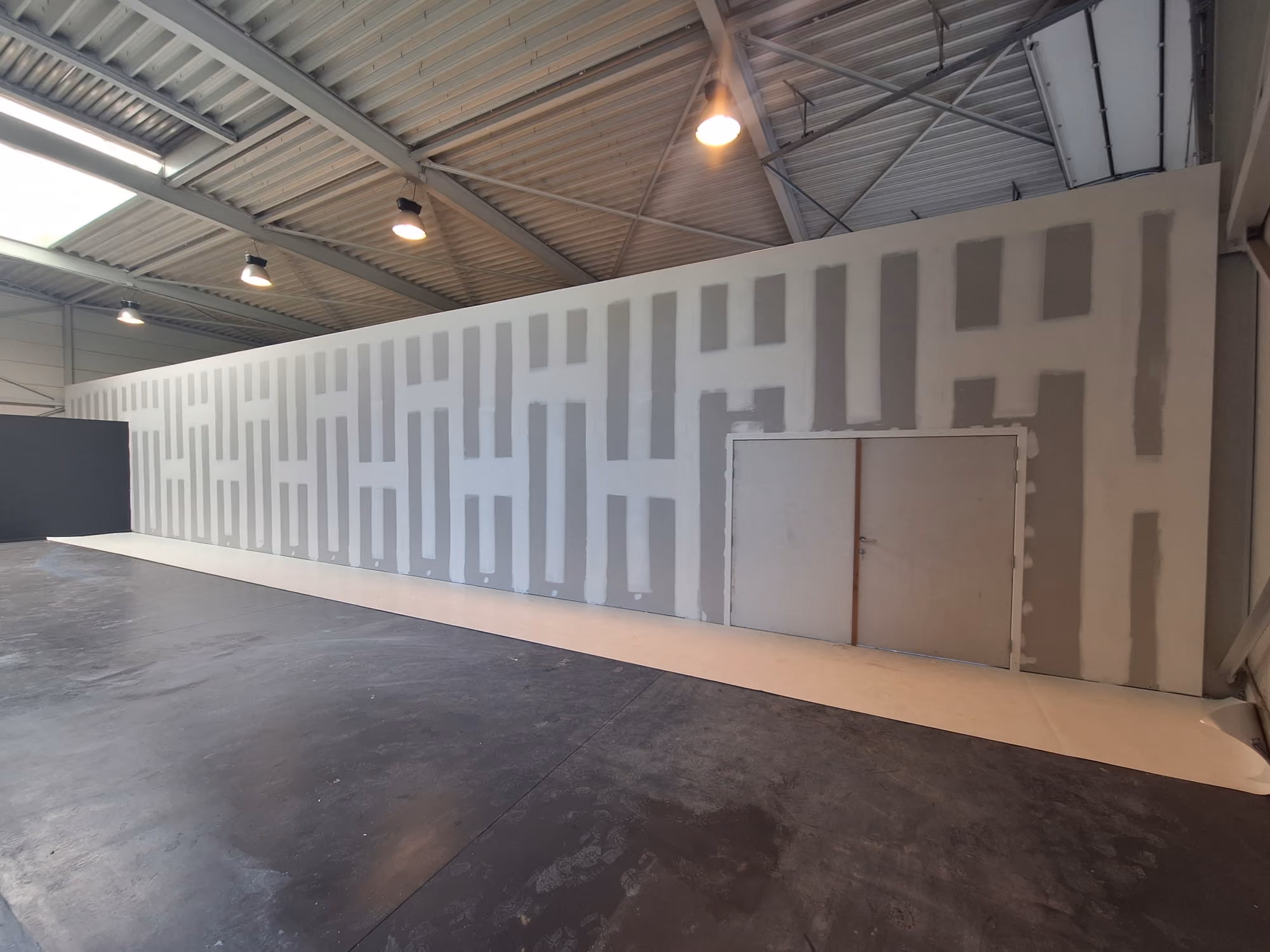 Zaal met daarin muur van gyproc in opbouw