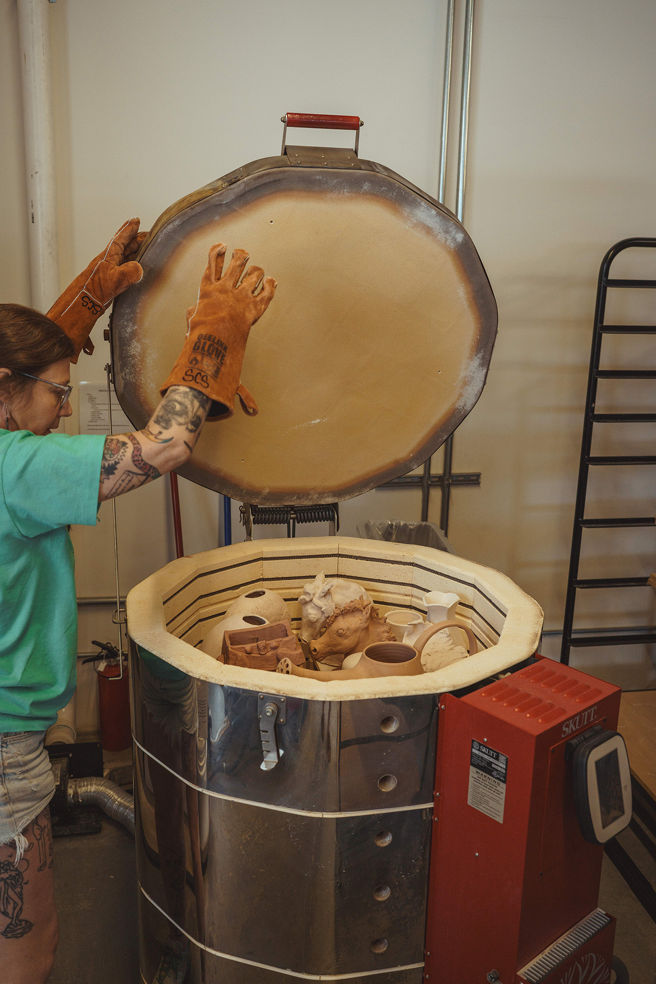 Rachel Yas opening one of the studios Cone 10 kilns where finished pieces emerge from the unpredictable heat of the firing process