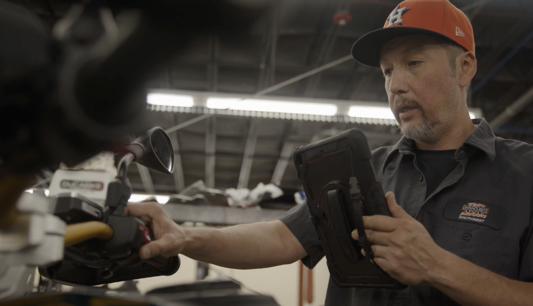 A technician making a Quik video of a motorbike