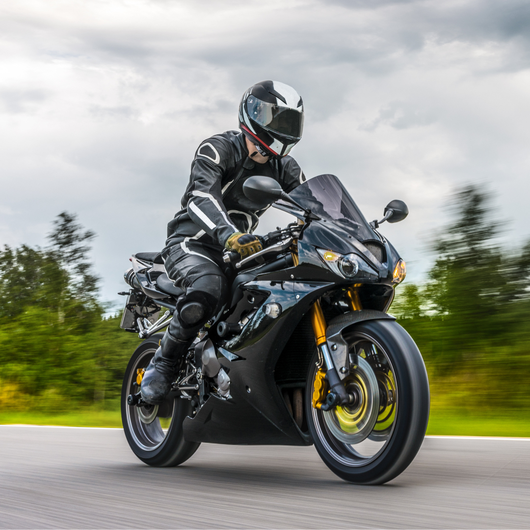 A person riding a black motorbike on the road