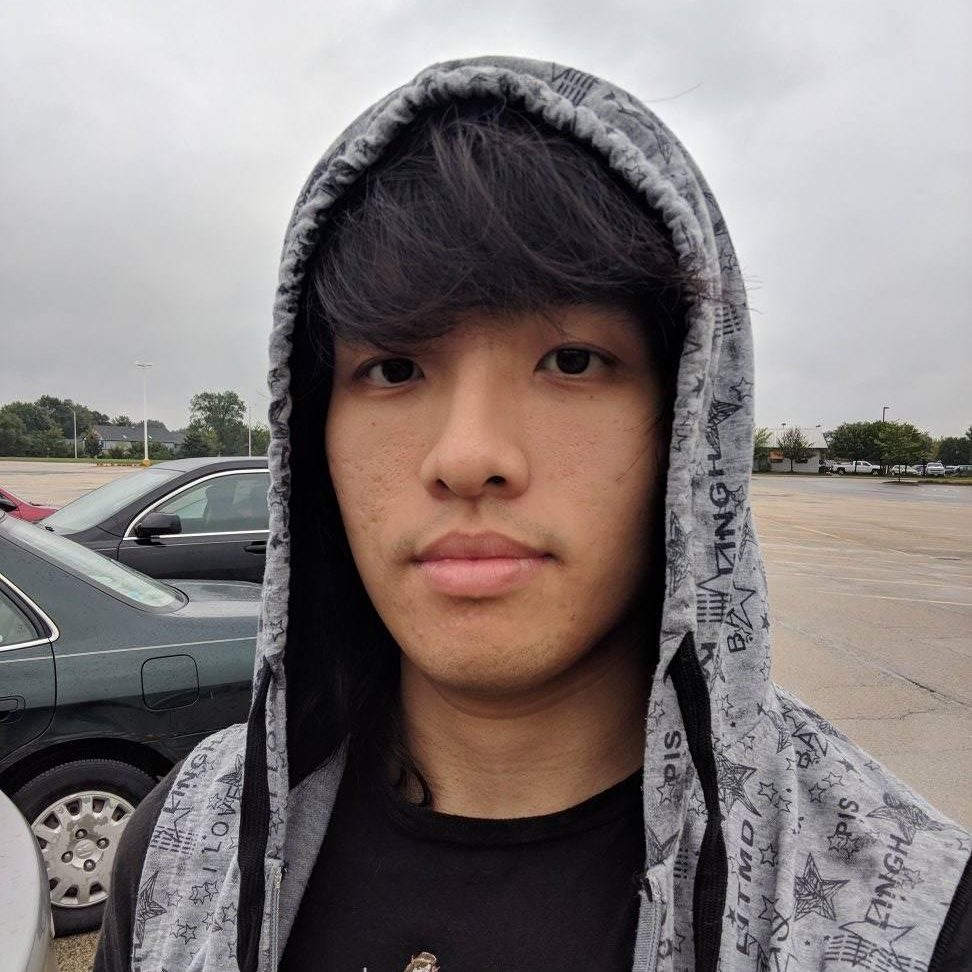 Asian man in grey hoodie.