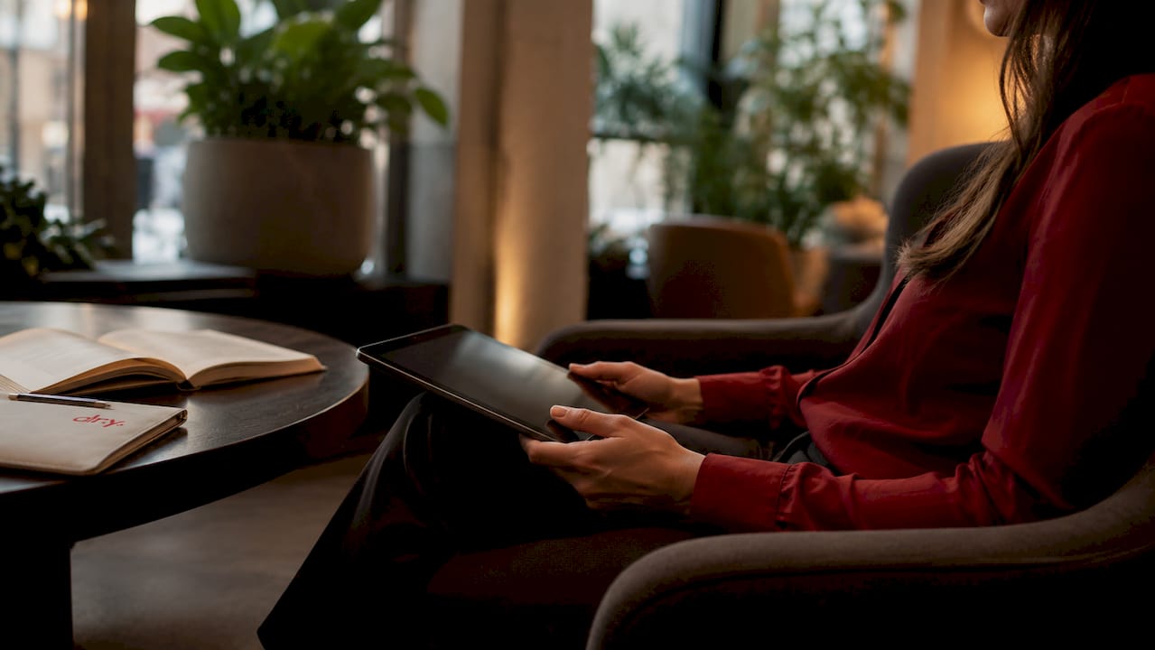 Des mains posées sur une tablette, au cœur d’une agence de marketing.