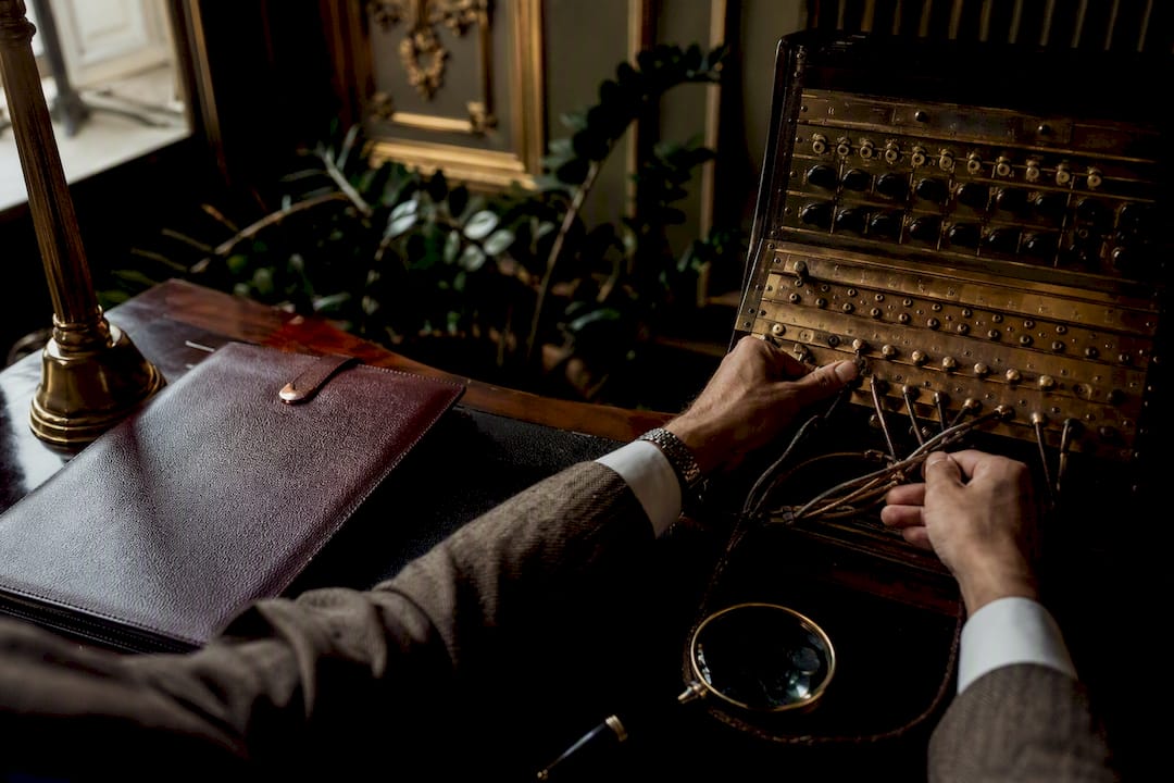 Mains connectant un ancien standard téléphonique dans un bureau peu éclairé
