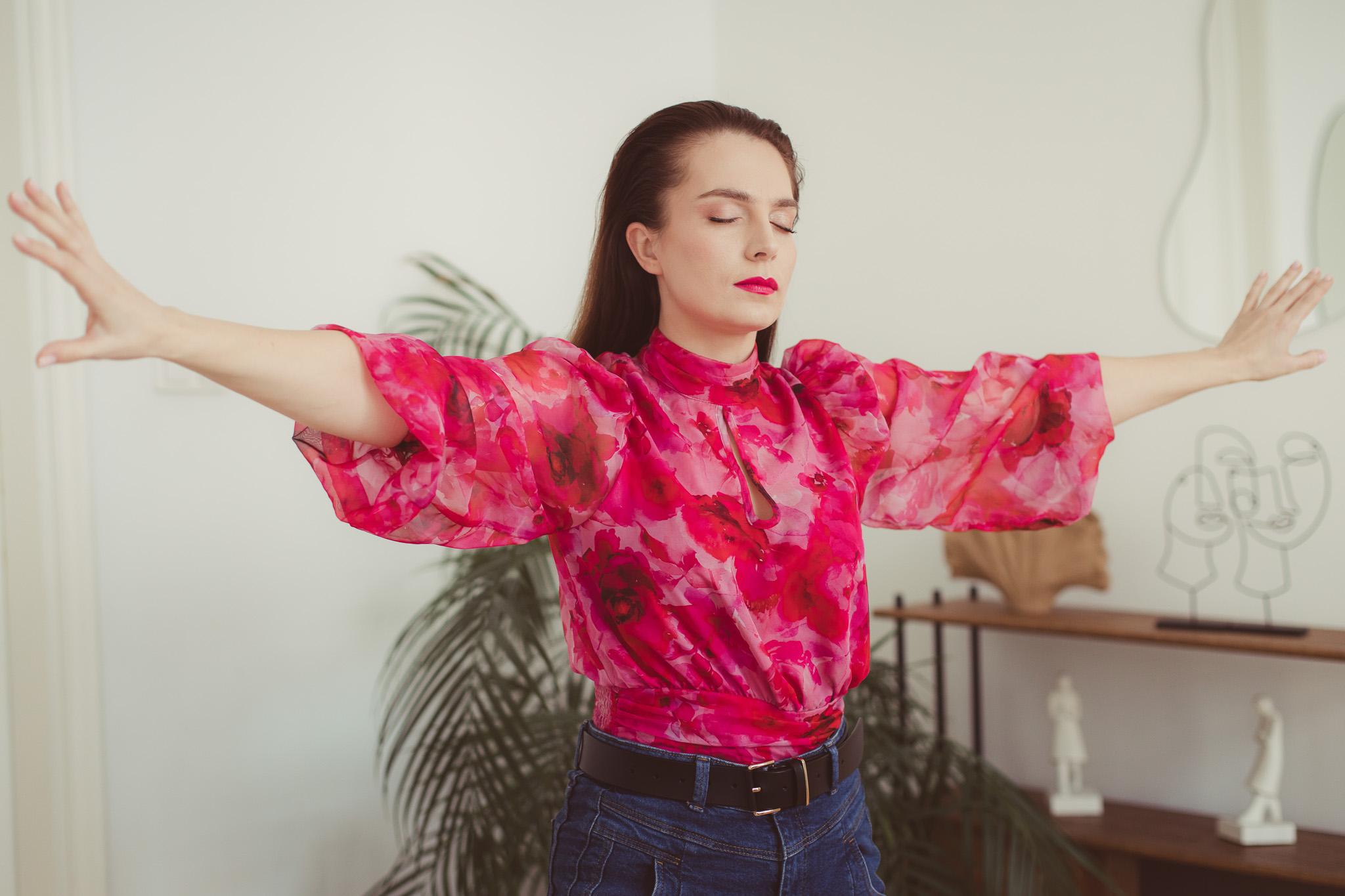 Nina Minor ubrana w różową bluzkę z falbanką w dużym skupieniu aktorka