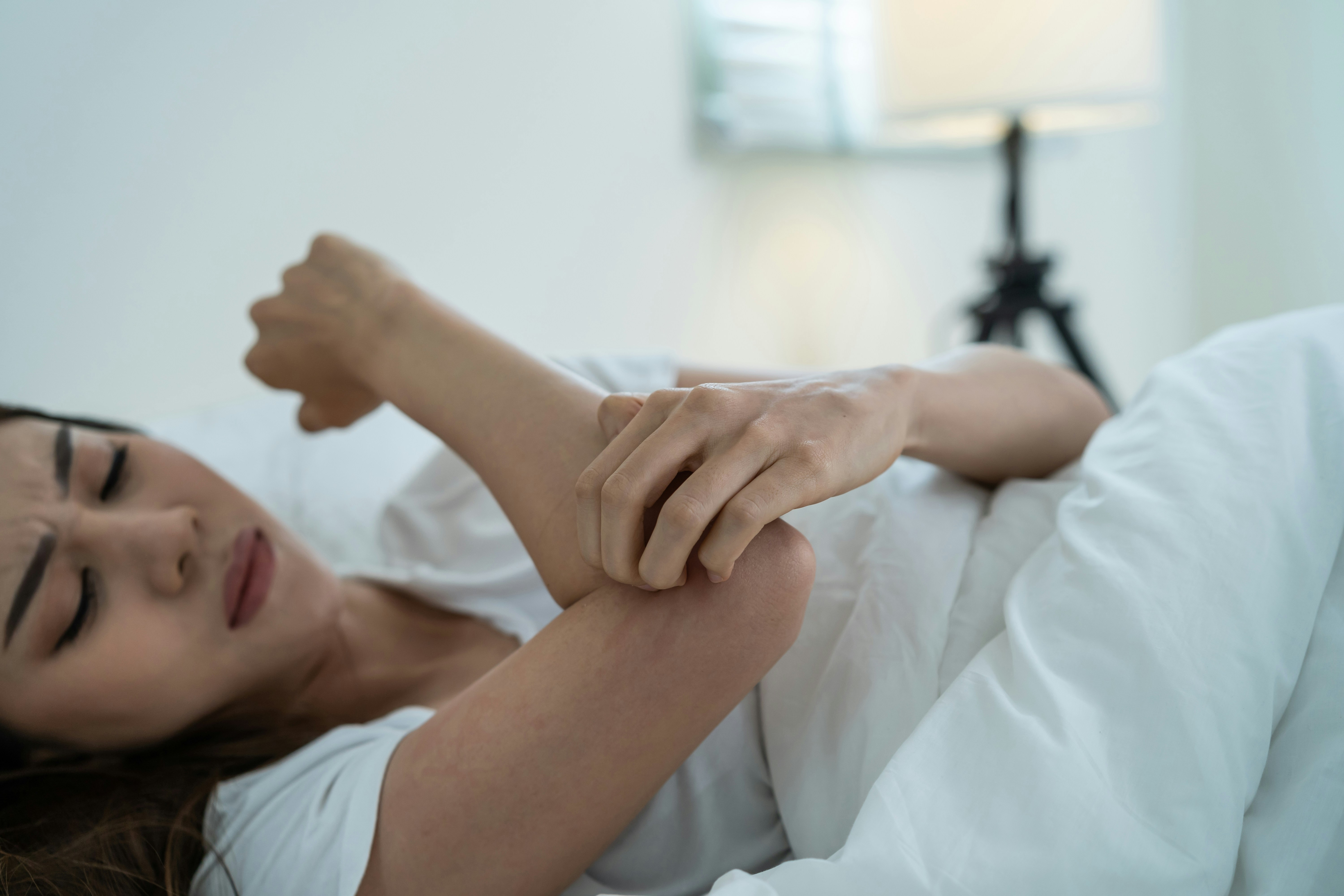 Woman examining dry itchy skin on her arm during perimenopause transition