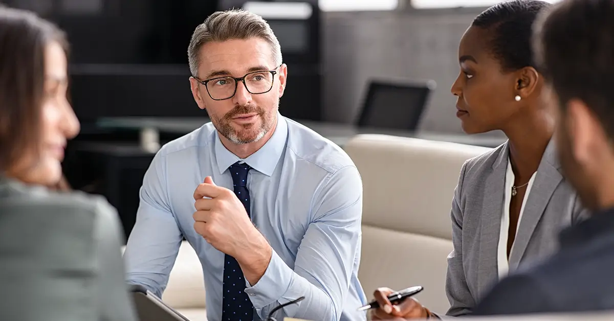 Professional procurement team meeting in modern office, discussing AI strategy, contract metrics, ROI analysis, and leadership reporting for business growth.