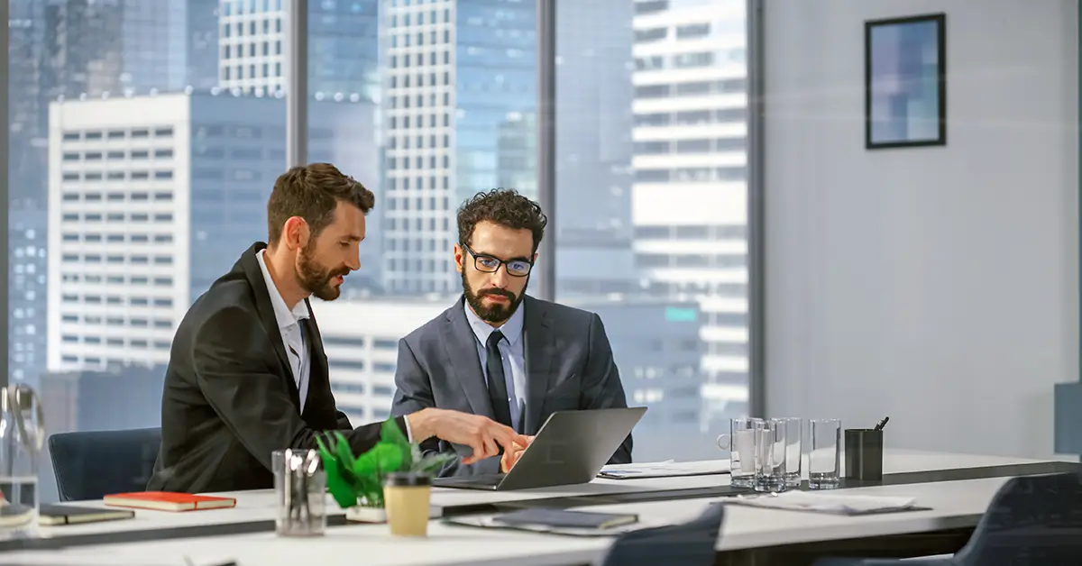 Two professionals collaborating on contract review in office, reflecting enterprise contract lifecycle management workflows
