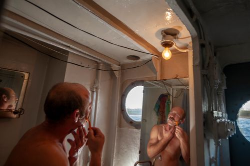 River sailor Zbigniew Laskowski shaves in a ships bathroom, during a transport cruise, on the Odra.