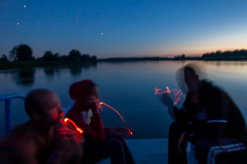 Crew of a transport ship, from left Zbigniew Laskowski, Maria Szukalska, Łukasz Szymański rest on deck under starry sky.