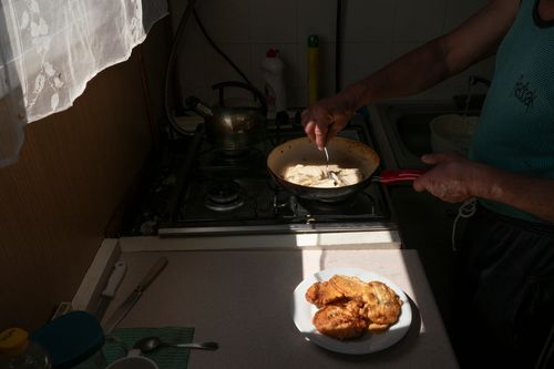 River sailor Piotr Klag fries apple pancakes for lunch in ship's kitchen, during a transport cruise on the Odra.