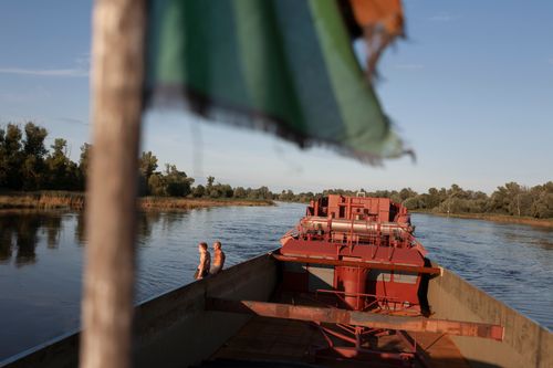 River sailors, from left Piotr Karpacz, Zbigniew Laskowski, sit on the side of a barge, during a break in their work.