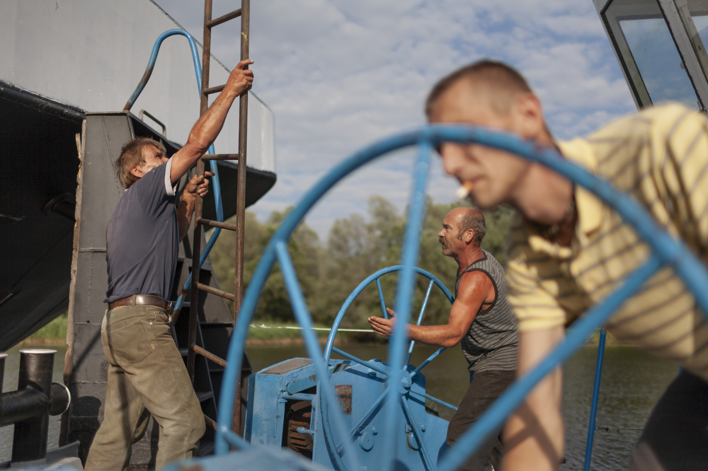 River sailors from left: Mieczyslaw Kozyra, Zbigniew Laskowski, Łukasz Szymański work on a ship at the barge's destination port.