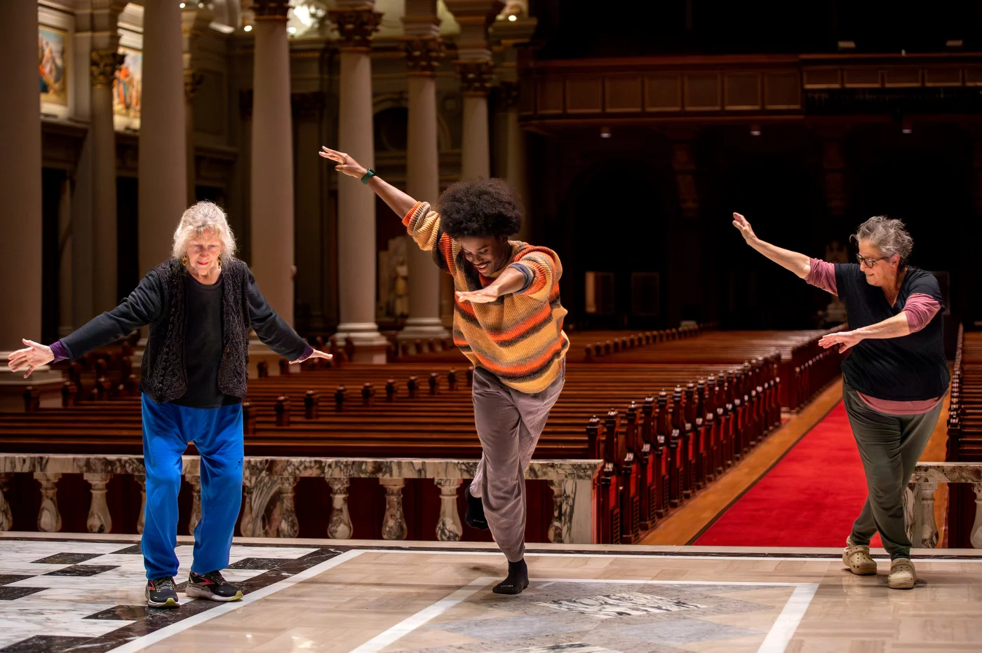 A young dancer initiates a movement — the elders follow, echoing gesture with grace, bridging age through shared motion.