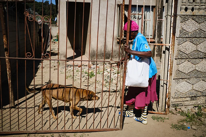 Shelta Nhengo, 75, arrives at her home after conducting session at nearby clinic in Mbare. Community health workers, predominantly composed of elderly women, offer voluntary counselling services to individuals who lack access to mental health services.