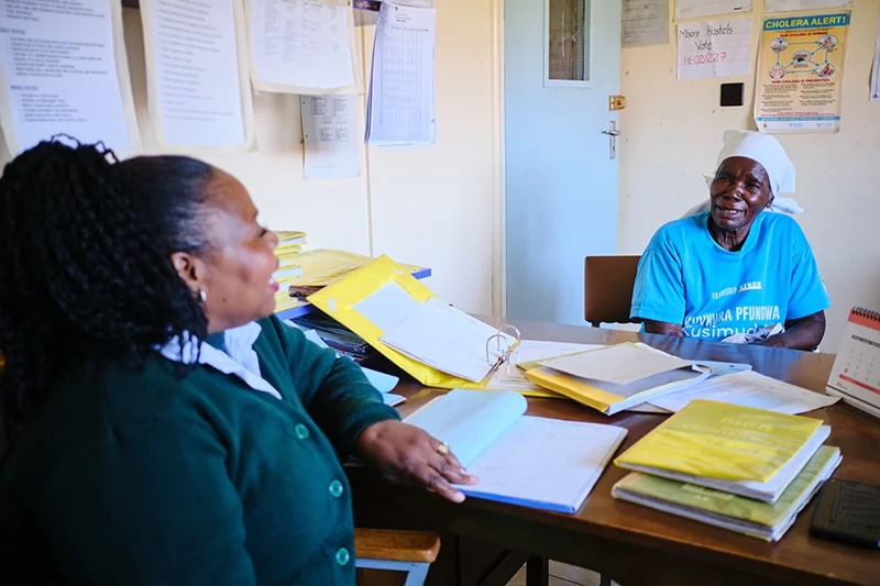 Shelta Nhengo, 75, chats to Fungai Chiutsi, the woman in charge at Mbare Hostels Clinic.