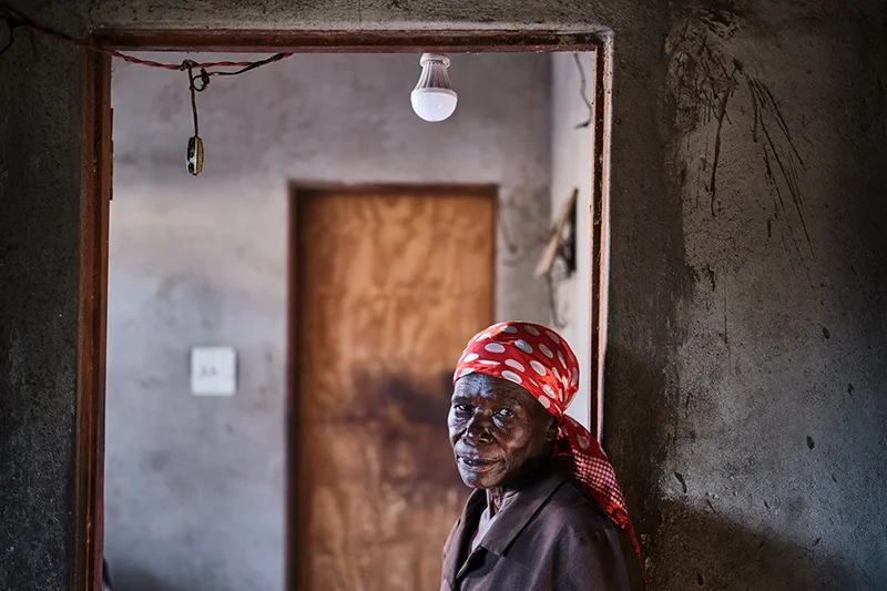 Shelta Nhengo, a 75-year-old of poses for portrait inside her house in Mbare township after conducting a door-to-door follow-up with patients who neglect to collect their medications from the clinic.