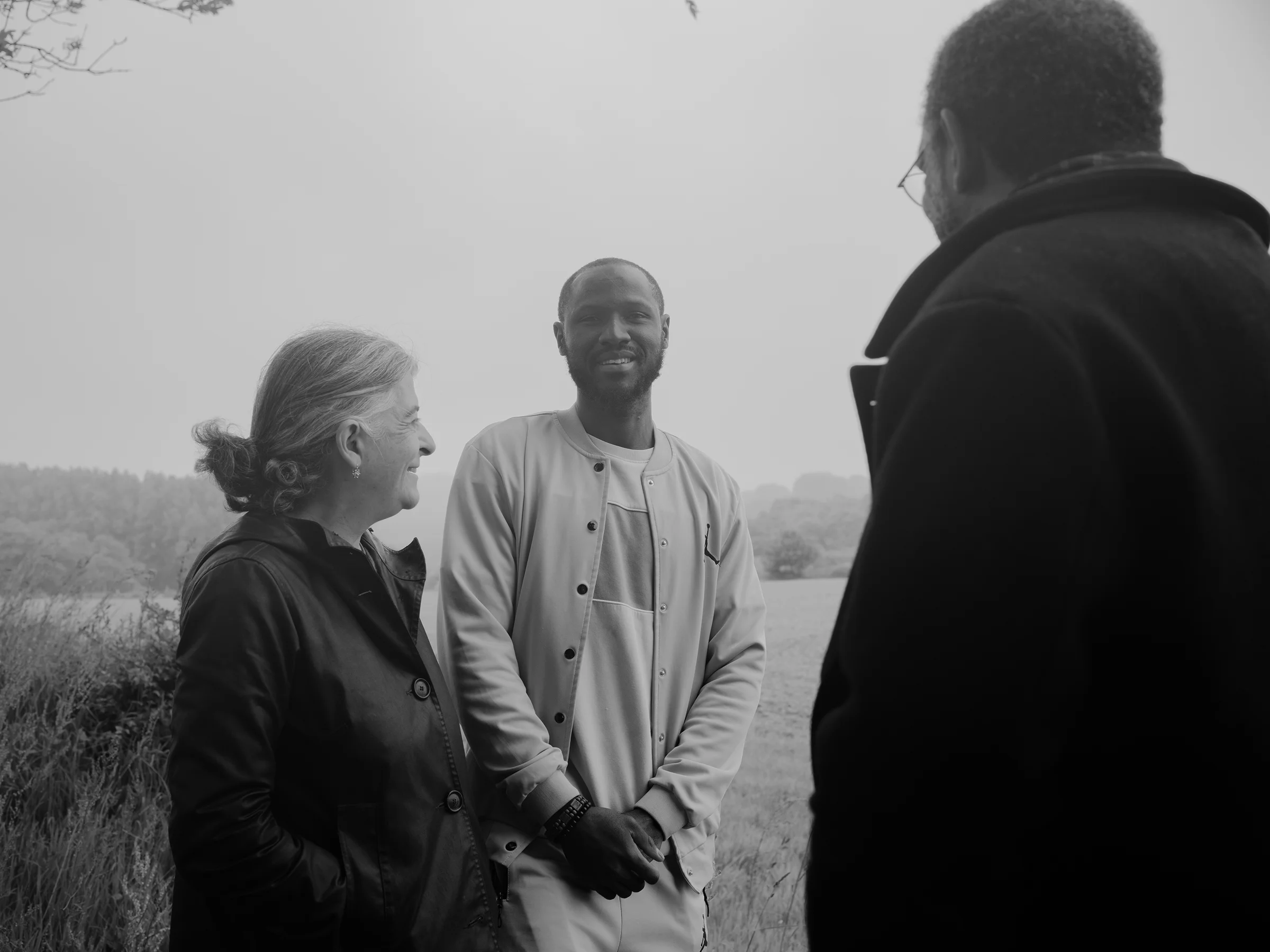 Alhassane, Arianne and Valéry talking and laughing together on the cliffs near their home in Normandy during a rainy day.