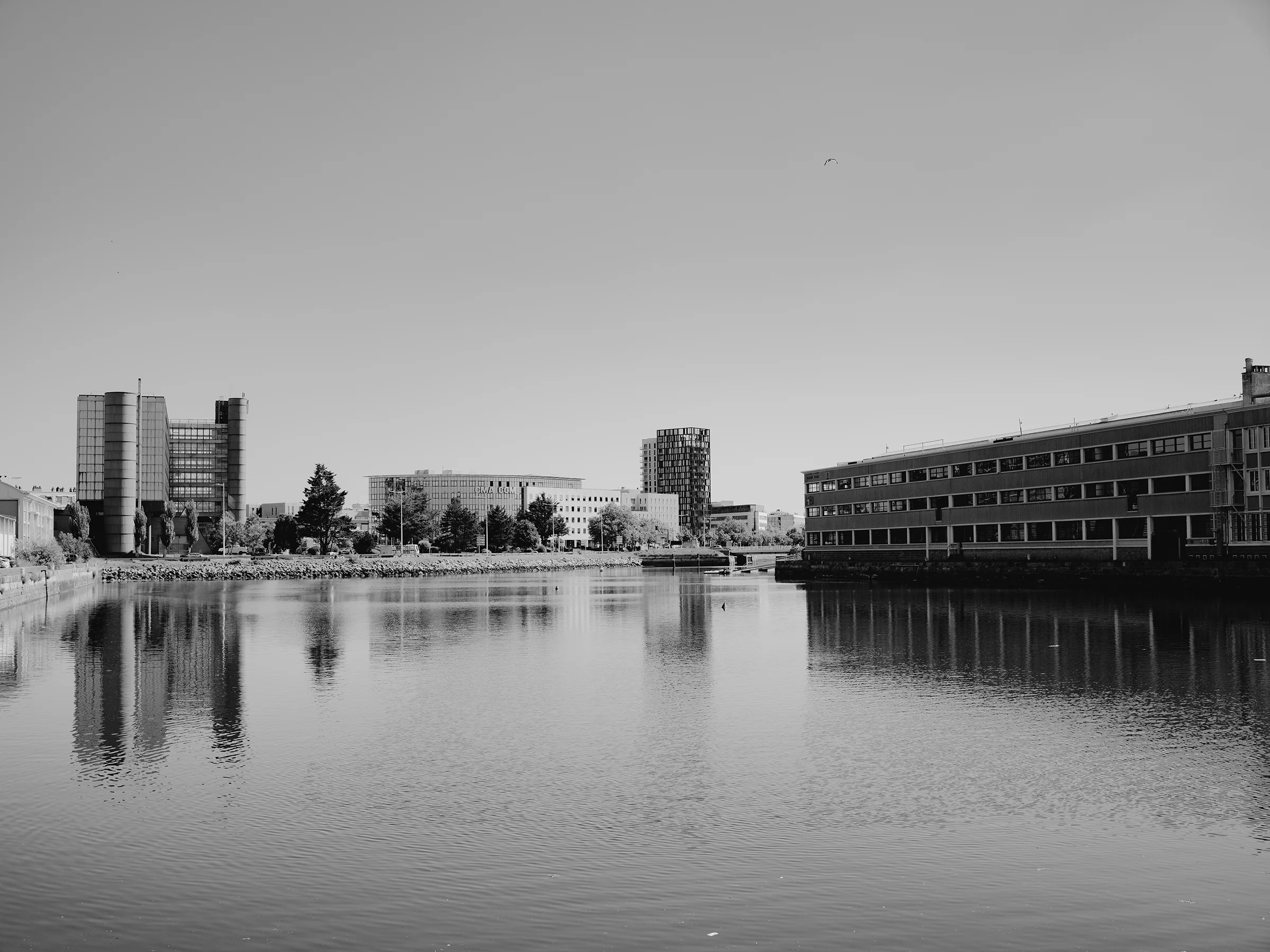 Buildings in Le Havre reflecting on the waters of the port, a city that became a home and crossroads for many unaccompanied migrant minors.