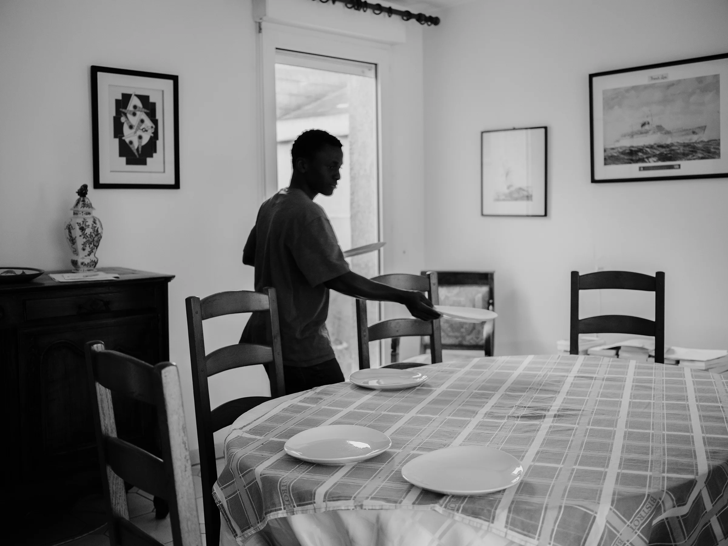 Ousmane, 16, preparing the table for lunch at Marianne’s home in Le Havre.