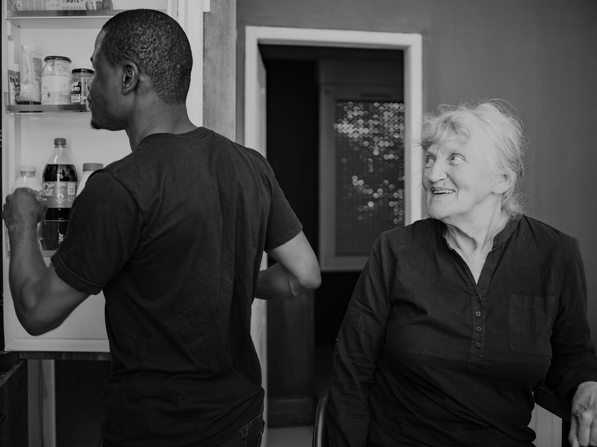 Véronique and Ahmad in his kitchen in Le Havre, sharing a quiet moment as Ahmad looks in the fridge for something to share.