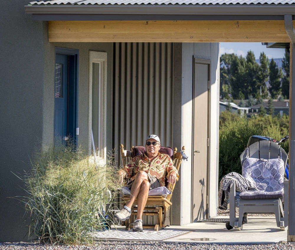 Tom (65) spends mornings on his porch watching the neighborhood activities, always welcoming those who stop by for a visit. His visibility and availability to other neighbors is what is intended with the building design of the homes.