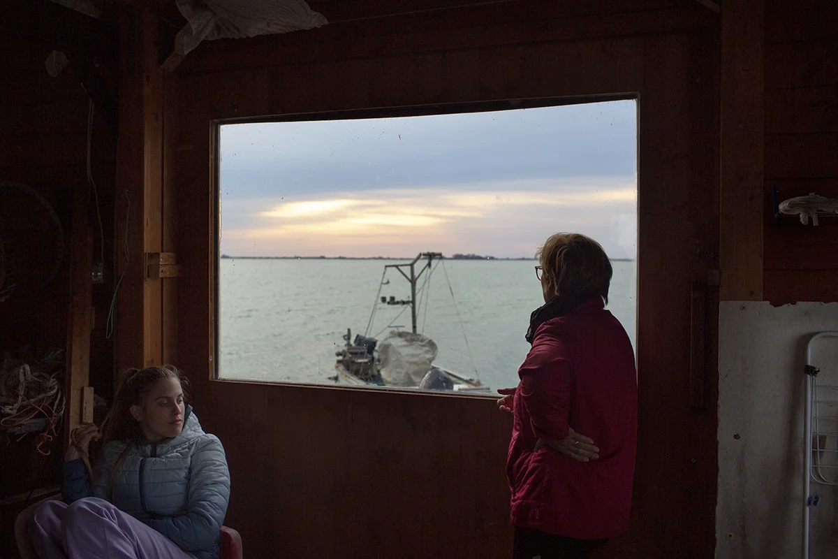 Chiara Vallati and her mother Barbara relax in their houseboat, where they store fishing gear and spend time together watching the lagoon.
