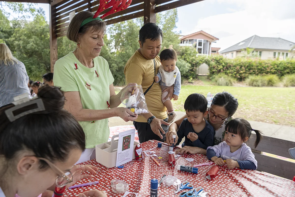 Father, mother and their 3 children participate together making Christmas decorations as co-leader, Elizabeth, hands out craft materials at Livvi's Place Ryde. The craft sessions nurture imagination and creative play between old and young. Dec 17, 2025